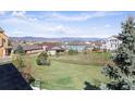 A scenic view of the backyard overlooking neighborhood homes and mountains in the distance under a sunny sky at 3893 Ute Mountain Trl, Castle Rock, CO 80109