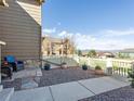 Cozy outdoor patio featuring two chairs, a small stone table, and decorative potted flowers at 3893 Ute Mountain Trl, Castle Rock, CO 80109