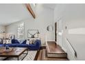 Bright living room featuring vaulted ceiling, hardwood floors, and a comfortable blue sofa at 27732 Squaw Pass Rd, Evergreen, CO 80439