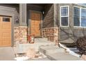 Close-up shot of the home's entrance, showcasing a multi-panel front door and brickwork at 25871 E 5Th Pl, Aurora, CO 80018