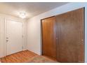 Bright entryway with wood laminate flooring, closet with sliding doors, and a white front door at 2700 S Holly St # 115, Denver, CO 80222