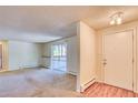 Spacious living room with neutral carpet and a sliding glass door leading to the outside at 2700 S Holly St # 115, Denver, CO 80222