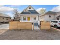 Inviting home exterior with yellow front door, wood fence, and partial blue shingle roofing at 5123 Milwaukee St, Denver, CO 80216