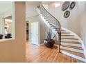 Foyer featuring hardwood floors and a curved staircase with decorative wrought iron at 4965 Huntwick Pl, Highlands Ranch, CO 80130