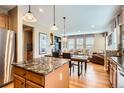 Open floor plan shows kitchen island, dining table and living room with lots of natural light at 4965 Huntwick Pl, Highlands Ranch, CO 80130