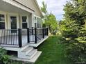 Inviting back porch with black railings and stairs that leads to a green lawn area at 6013 Eldora St, Golden, CO 80403