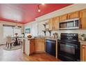 Traditional-style kitchen with wood cabinets, updated appliances, and adjacent eat-in dining area at 20535 E 47Th Ave, Denver, CO 80249