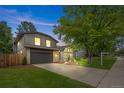 Charming gray two-story home featuring a well-manicured lawn, mature trees, and inviting curb appeal at 11035 E Berry Ave, Englewood, CO 80111