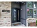 Inviting front entrance featuring a stylish black door with glass accents and brick and gray siding at 11035 E Berry Ave, Englewood, CO 80111
