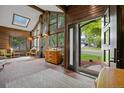 Bright living room with skylight, wood paneling, brick floors, and a view of the front yard at 11035 E Berry Ave, Englewood, CO 80111