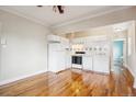 Open concept kitchen and living room with white appliances and hardwood floors at 1351 N Washington St # 23, Denver, CO 80203