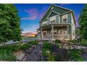 Inviting covered porch with seating offers views of the beautifully landscaped front yard at 881 Kirby Ct, Watkins, CO 80137