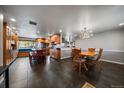 Spacious kitchen and dining area featuring custom wood cabinetry, large island, and modern lighting at 13464 W Virginia Dr, Lakewood, CO 80228