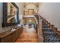 Grand foyer showcases a sweeping staircase with iron railings, hardwood floors, and soaring ceilings at 8090 S Homesteader Dr, Morrison, CO 80465