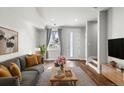 Bright living room with hardwood floors, gray sofa, and a large window with stylish curtains at 3875 E 4Th Ave # 2, Denver, CO 80206