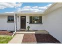 A freshly painted home features a welcoming front door and meticulously maintained landscaping at 6068 Lee St, Arvada, CO 80004