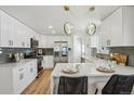 Bright kitchen features white cabinets, stainless steel appliances, pendant lighting, and quartz countertops at 6068 Lee St, Arvada, CO 80004