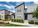 Modern gray townhouses with tidy landscaping and a welcoming walkway under a blue sky at 16203 E 47Th Pl, Denver, CO 80239