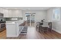 Bright kitchen with stainless steel appliances, white cabinets, and eat-in counter at 760 W Asbury Ave, Denver, CO 80223