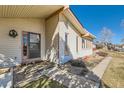 A charming home featuring light siding, a covered porch and meticulously maintained front yard landscaping at 57 Scott S Dr, Broomfield, CO 80020