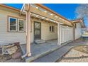 Rear view of a well-kept home featuring a covered patio area with bright white fencing and ample natural light at 57 Scott S Dr, Broomfield, CO 80020