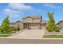 Two-story brick home with a three car garage, a well-manicured lawn and mature trees at 7380 S Shady Grove Way, Aurora, CO 80016