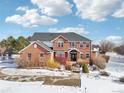 Brick home with a large yard; winter scene at 221 Mulligan Lake Dr, Mead, CO 80542