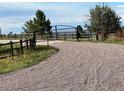 Gravel driveway leading to a gated property with fenced boundaries, offering privacy and security at 7113 Echo Hills Club Rd, Larkspur, CO 80118