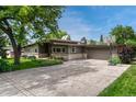 Attractive single-story home with a long driveway, basketball hoop, and mature landscaping at 5 Hillside Dr, Wheat Ridge, CO 80215