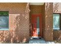 Close up of brick condo entrance with red door and modern windows at 2335 Walnut St # 10, Denver, CO 80205