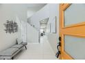 Bright foyer with white tile, modern bench, and a view through to the living area at 10910 Touchstone Loop, Parker, CO 80134