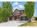 Charming two-story home with a three-car garage, stone accents, and well-maintained landscaping at 14958 Wistera Way, Broomfield, CO 80023