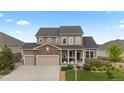 Charming two-story home with stone accents, a well-manicured front yard, and a two-car garage at 23252 E Glidden Dr, Aurora, CO 80016