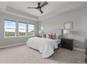 Spacious main bedroom with tray ceiling, three large windows, and neutral decor at 23252 E Glidden Dr, Aurora, CO 80016