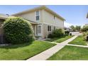 Exterior of condo with well-maintained front lawn and a paved walkway at 6650 E Arizona Ave # 203, Denver, CO 80224