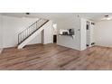 Open-concept living room, hardwood floors, staircase, and breakfast bar at 6650 E Arizona Ave # 203, Denver, CO 80224