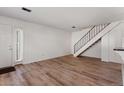 Open-concept living room with wood floors, white walls, and staircase at 6650 E Arizona Ave # 203, Denver, CO 80224