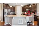 Well-equipped kitchen featuring granite counters, dark wood cabinets, and stainless steel appliances at 4834 S Wenatchee St, Aurora, CO 80015