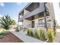 Modern condo exterior with balcony, black railings, and well-maintained landscaping at 2400 S Delaware St # 1, Denver, CO 80223