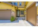 Inviting entryway showcasing a modern front door, sidelights, and two-car garage at 14074 Yellow Tip Dr, Parker, CO 80134
