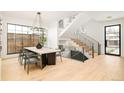 Dining room with statement chandelier, staircase, and view of back yard at 535 Albion St, Denver, CO 80220