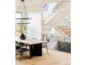 Dining room with decorative staircase, light hardwood floors, and designer chandelier at 535 Albion St, Denver, CO 80220