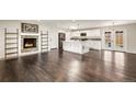 Open-concept kitchen featuring white cabinets, an island, and hardwood floors at 6614 Everett St, Arvada, CO 80004