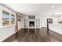 Bright living room featuring hardwood floors, a fireplace, and large windows at 6614 Everett St, Arvada, CO 80004