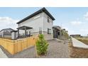 Exterior side view highlighting the stone accents, small tree, and wooden fence at 6225 N Nepal Ct, Aurora, CO 80019