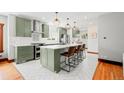 Modern kitchen featuring green cabinetry, marble countertops, and stainless steel appliances at 4945 Perry St, Denver, CO 80212