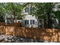Townhouse with freshly stained wood fence, inviting entrance, and lush green trees at 12558 E Tennessee Cir, Aurora, CO 80012
