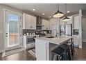Bright kitchen with white cabinets, center island and stainless appliances at 6805 Canosa St, Denver, CO 80221