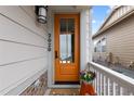 Inviting front entry door with glass panel, bright paint, house number, and a welcoming porch at 2020 Sagerock Dr, Castle Pines, CO 80108