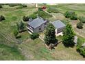 Aerial view of a beautifully landscaped home with spacious yard, mature trees, and fenced perimeter at 9163 N Palomino Dr, Castle Rock, CO 80108